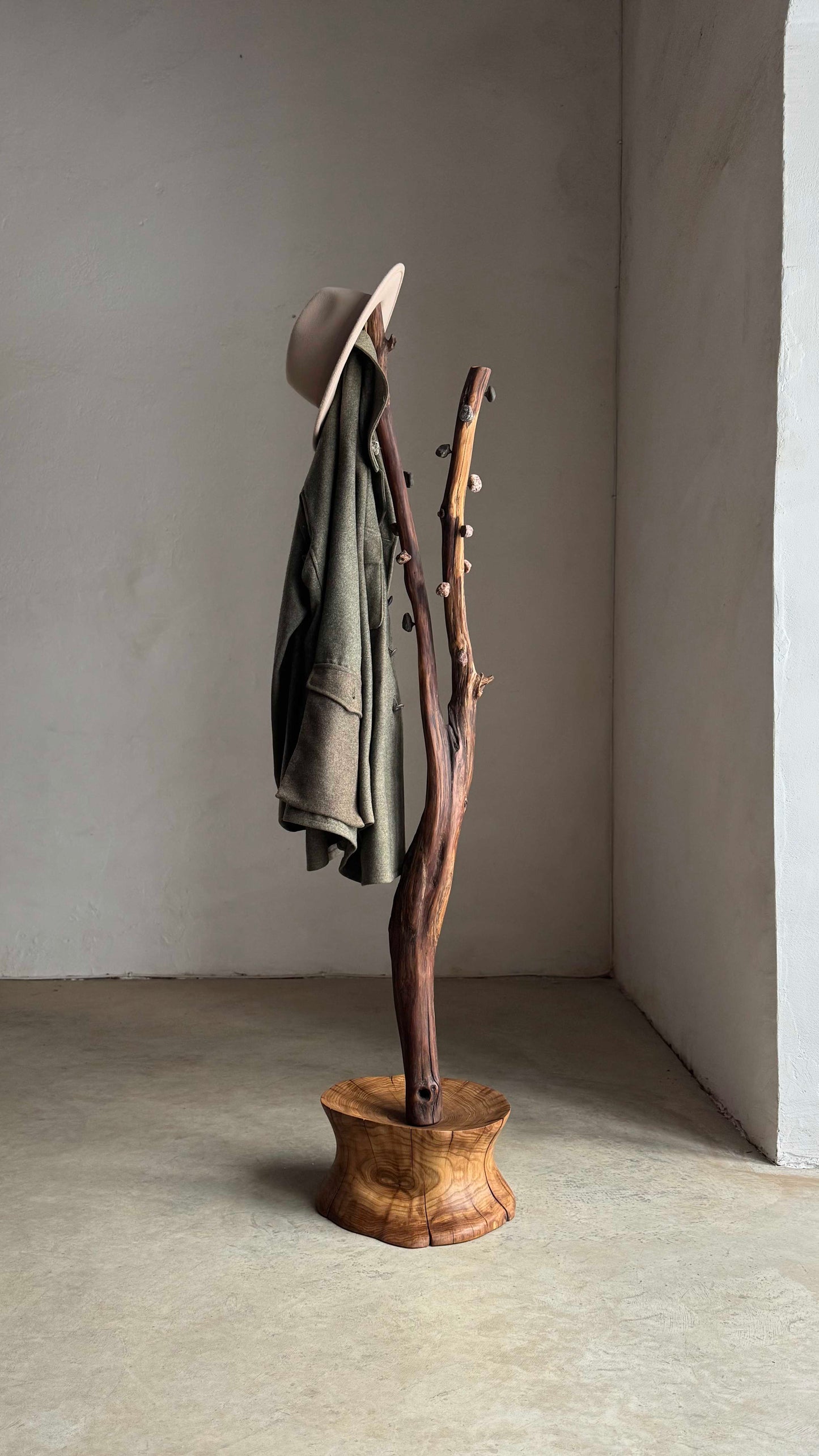 Oak Coat Rack with Stone Hooks with a jacket and a at on it